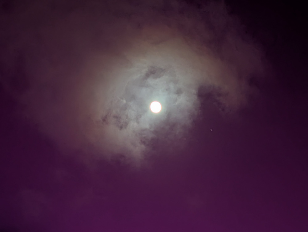 The moon surrounded by clouds in the night sky